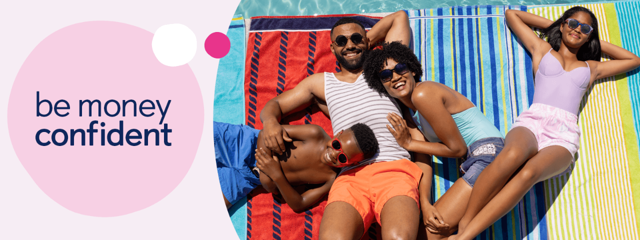Family laying on beach towels with a pool behind them