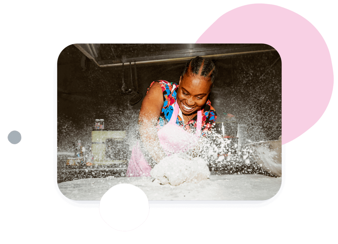 Person kneading dough with flour flying around them.