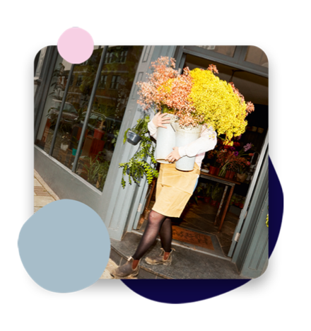 Person walking out of a flower shop with a bunch of yellow flowers