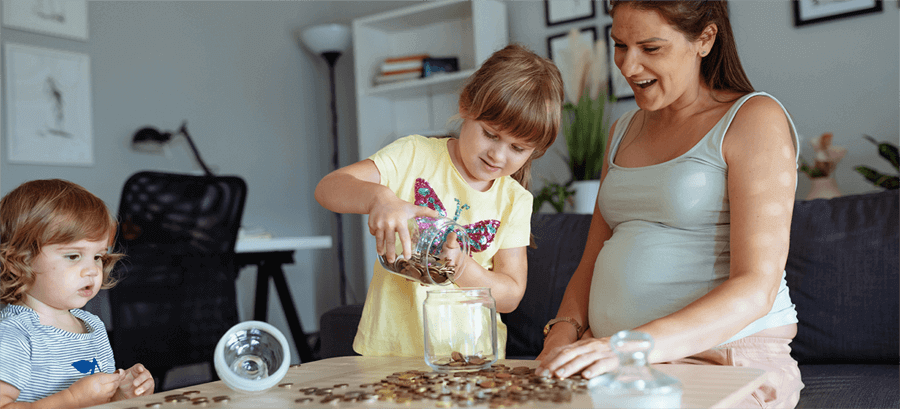 Woman sat on sofa watching child pours coins from one jar to another.