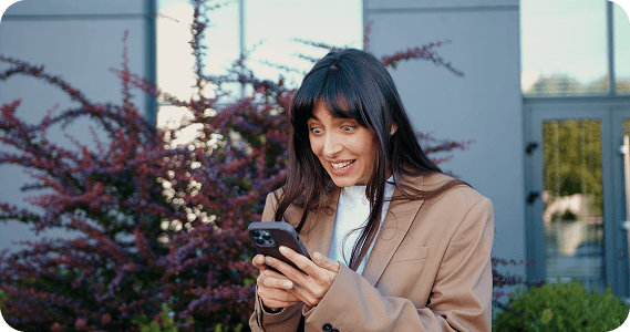 Woman excitedly looking at her mobile phone screen