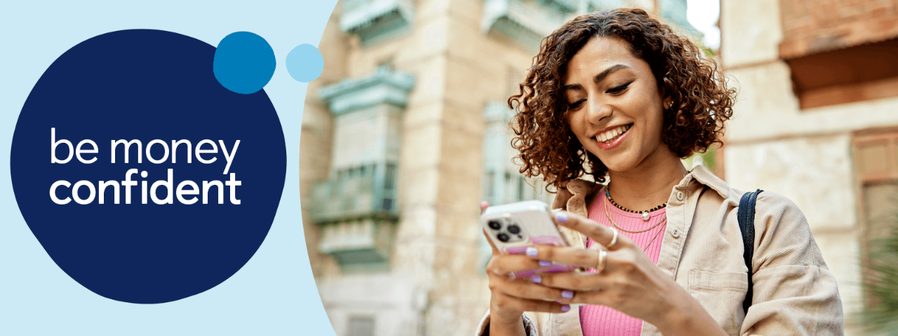 Person looking at their mobile phone outside building