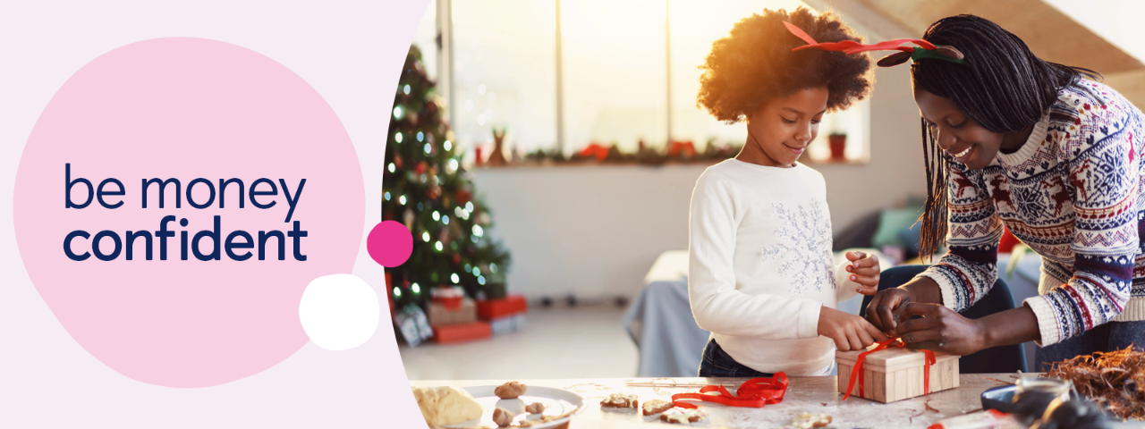 Adult and child wrapping gifts with Christmas tree in the background