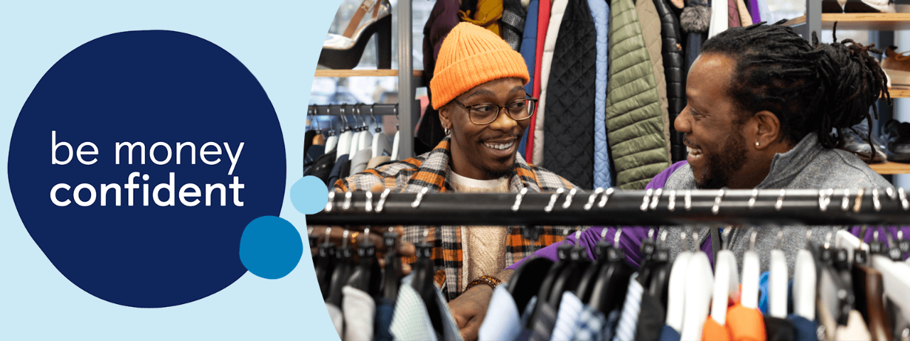 Two people looking at clothes on a rail in a shop