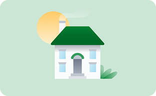 The sun behind a white house with a green roof and bushes.