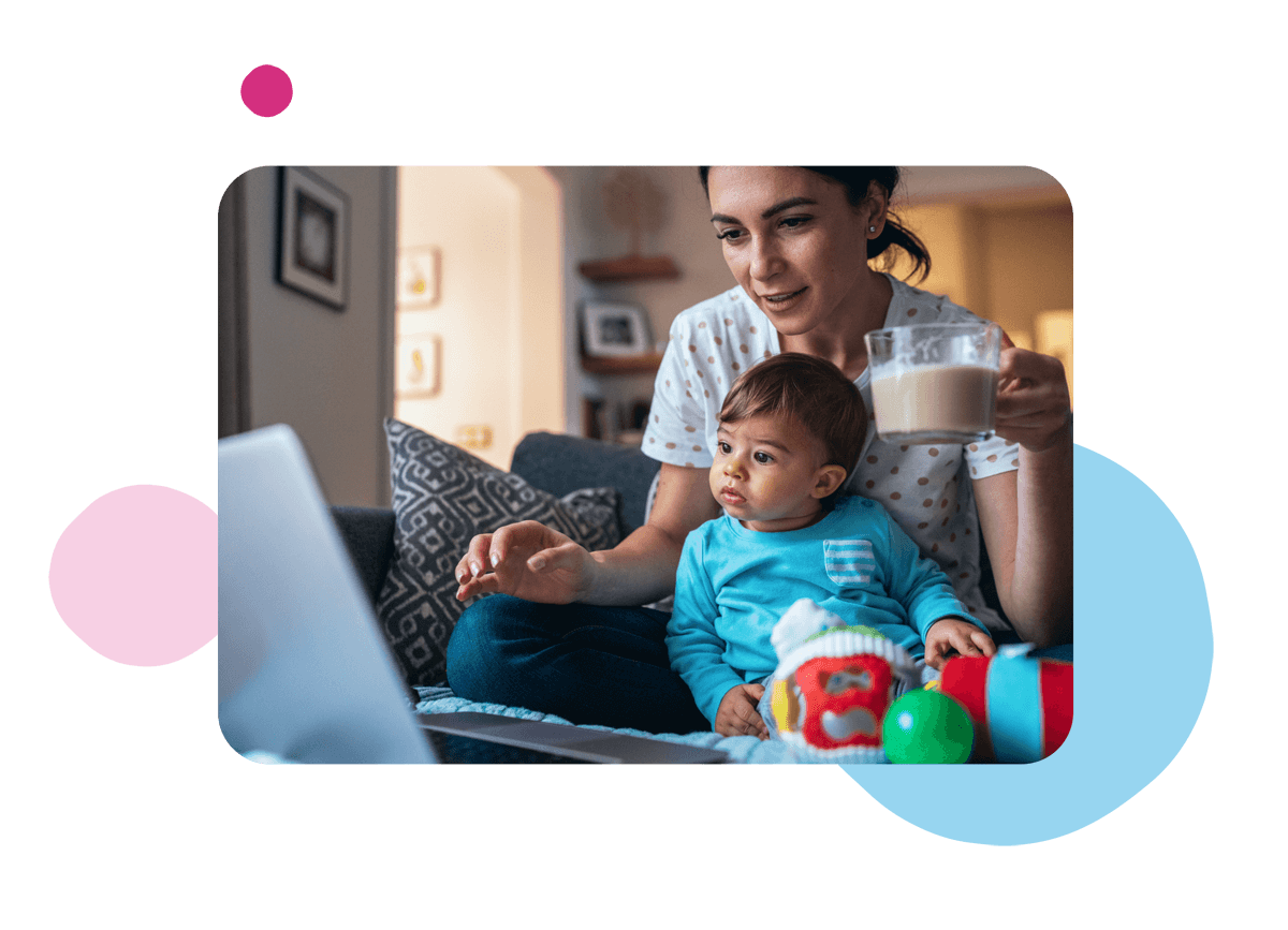 Person holding a mug looking at laptop with small child next to them Person holding mug and child whilst on a laptop.